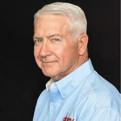 Older man in light blue shirt smiling